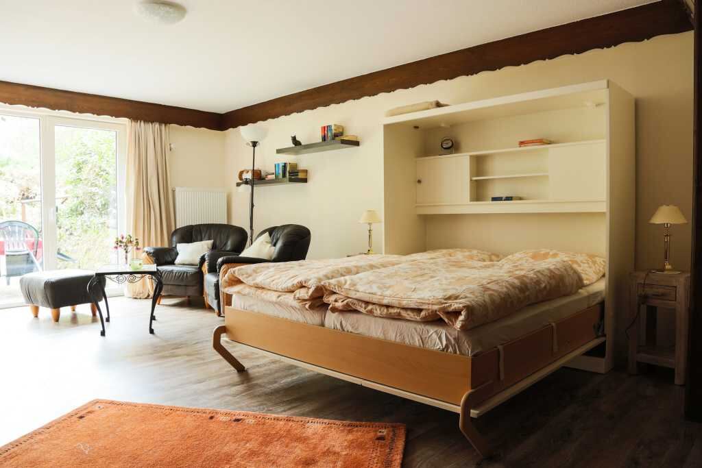Heller Wohn- und Schlafraum der Ferienwohnung mit Doppelbett und Sitzecke